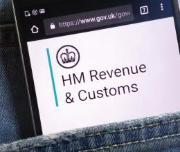 The UK government website for HM Revenue and Customs displayed on smartphone hidden in jeans pocket